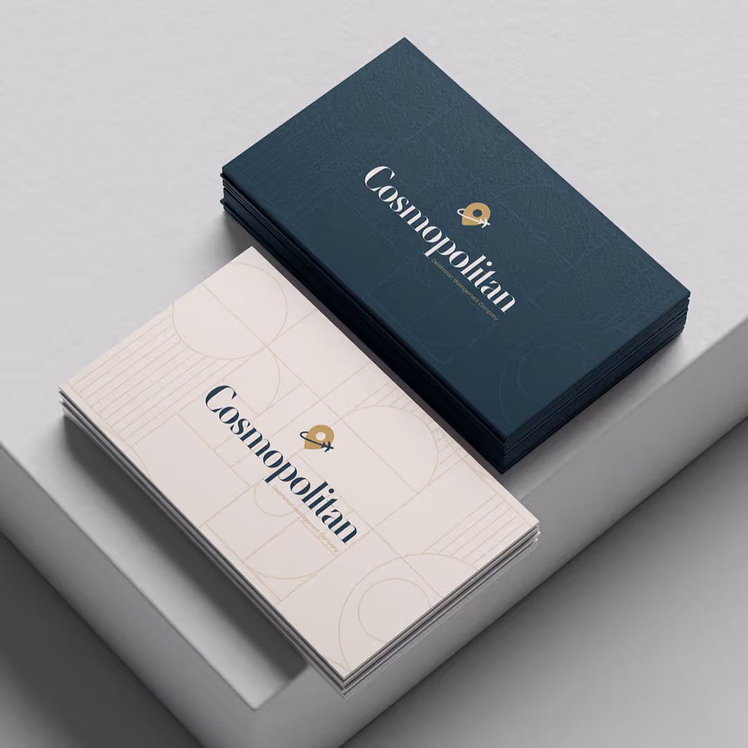 Navy and cream Cosmopolitan DMC business card mockups featuring the brand's gold compass logo.